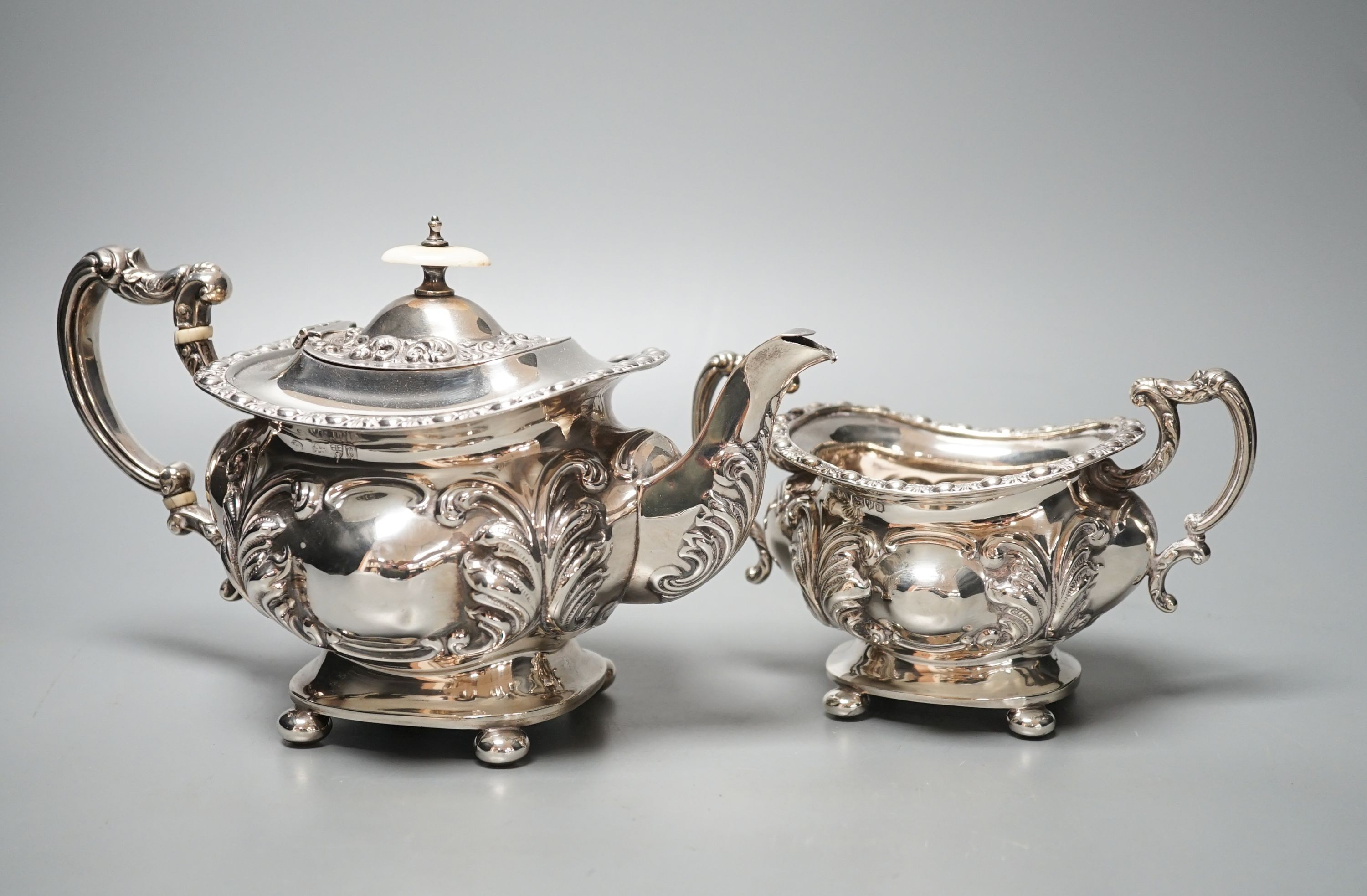 An Edwardian embossed silver teapot and matching sugar bowl, William Aitken, Chester, 1903, gross 21.5oz.